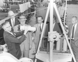 Paul M. Fye holding buoy-mounted instrument.