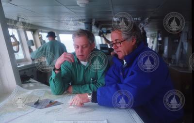 Dudley Foster and Charley Hollister looking over charts.