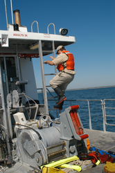 Ian Hanley, deck hand on Tioga, climbs ladder.