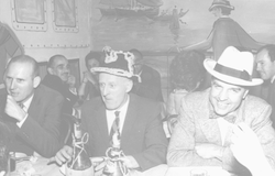Arthur Maxwell(L) at dinner with unidentified men.