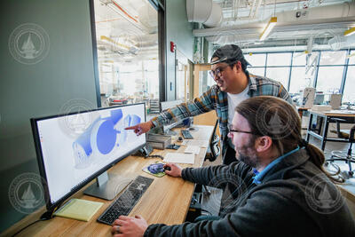 Solomon Chen and Matt Long analyzing a 3D printing engineering drawing.