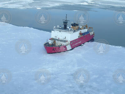 Aerial view of icebreaker USCG Healy partially into the ice.