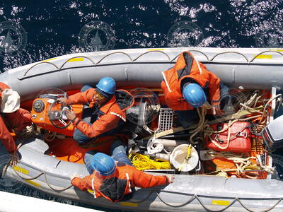 Crew in the zodiac as it heads out to repair the gulf stream buoy.