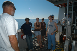 Hovey Clifford (white shirts) discussing sediment sampling with students.