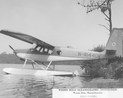 Helio courier on water near shore