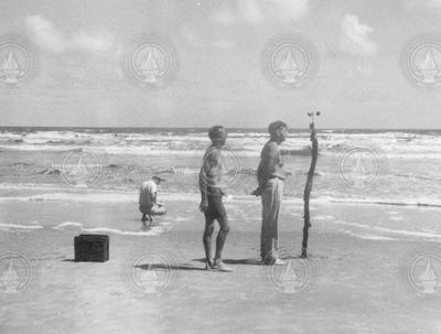 Al Woodcock (kneeling), Ted Spencer, and Andrew Bunker working on the beach.
