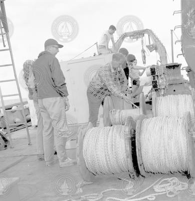 John Beckerle (left) and Warren Witzell (center) working with large spools on deck of Chain