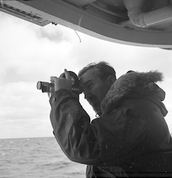 Photographer Jan Hahn on board R/V Atlantis II with a camera.