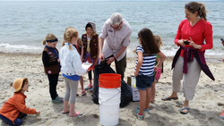 Jeffrey Brodeur and Heather Benway show local Brownies how to clean a beach.