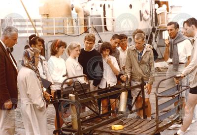 Columbus Iselin (far left) and Jan Hahn (far right with pipe) with students on dock in front of