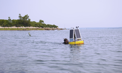 Matt Long deploying a solar-powered buoy off the Elizabeth Islands.