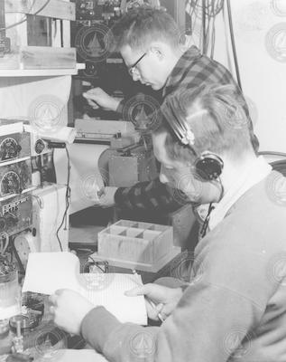 Hartley Hoskins and Karl Schleicher (with headset) working in lab aboard Crawford