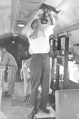 Ed Denton (left) and unidentified men working with equipment inside C54Q aircraft