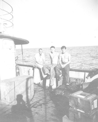 Three men sitting on rail of Mentor