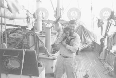 Don Fay holds ship's cat on Atlantis