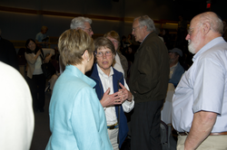 Susan Avery and John Farrington talking with an audience member after talks.