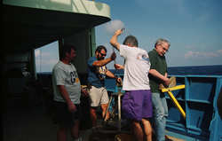 Dan Fornari (purple shorts) preparing a sediment grab sampler.