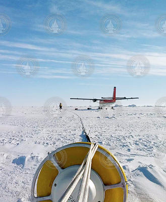 Ice buoy on the ice with the small transit plane in the background.