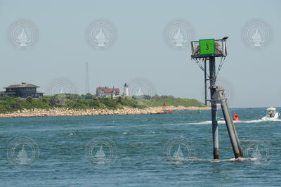 Osprey nest on Woods Hole channel marker 3, with Nobska in background.