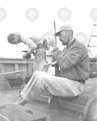 Bill Schevill and Dick Backus loading harpoon guns on Bear