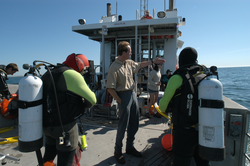 Ken Houtler, Captain, on deck of Tioga with diver and 2004 Ocean Science Journalism Fellows.
