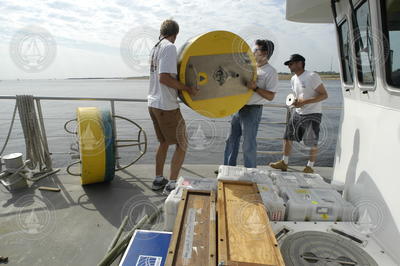 Malcolm Scully and Jim Lerczak carrying a recovered buoy