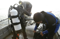 Jay Sisson and Pat Lohmann prepare to dive in search of a lost mooring