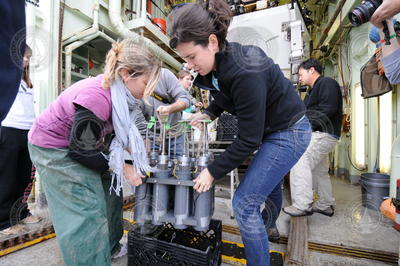 Amanda Demopoulos and Helen White retrieve core samples from Alvin's basket.