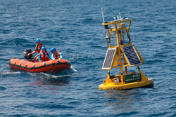 Josh Woodrow, Sara Haines, and Harvey Seim setting up sensor on a buoy.
