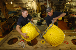 Kris Newhall and John Kemp examine and repair floats.