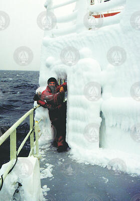 First mate George Silva next to a bulkhead door covered with ice.