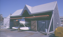 Dyer's Dock Hangar with Helio courier aircraft at doorway.