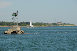 A sailboat passing through Great Harbor in front of Nobska Point.