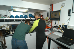 Heidi Sosik and Rob Olson work on the power supply for the flow cytometer.