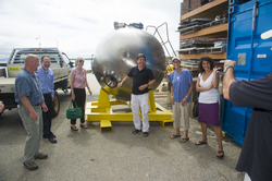 The group of visitors and tour guides gathered around the old Alvin personnel sphere.