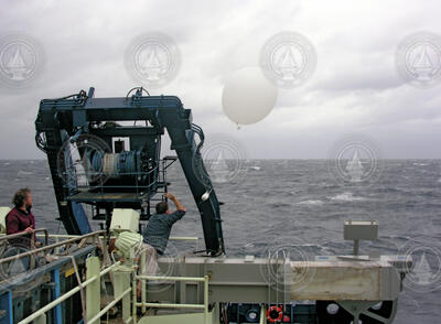 John Toole observes Jim Edson deploy a radiosonde weather balloon from Atlantis.