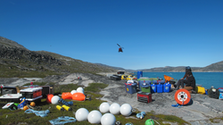 Helicopter arriving with equipment at Greenland research site.