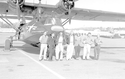 Group posing in front of PBY aircraft