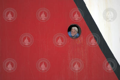 Steward Judith Joncas peers out from a porthole