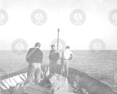 Three men working in bow of Mentor