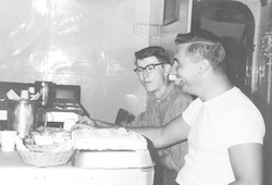 F. Beecher Wooding and Ernest Flood with birthday cake below deck