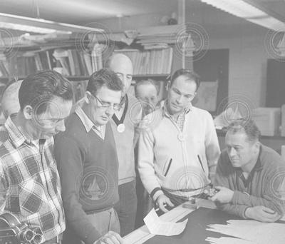 Arthur Miller (2nd from left) explaining charts.