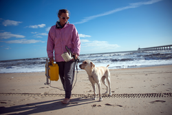 Britt Raubenheimer and her guide dog, Hugger, walking the beach in Duck, NC.