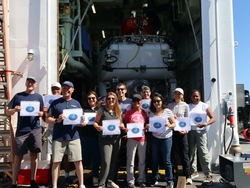 Alvin observers holding their first dive certificates in front of the sub.