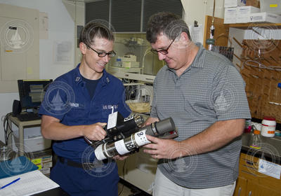 U.S. Coast Guard Lt. Jarett Parker transferring oil sample to Bob Nelson.