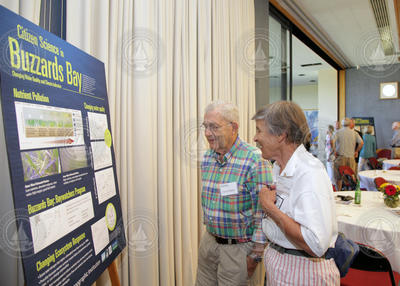 David Babin and Judy Stetson reading a science poster on display.