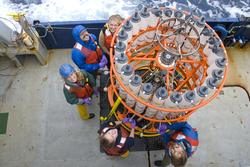 Researchers on deck preparing a CTD rosette for deployment.