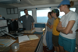 Captain Ken Houtler showing students electronic equipment.