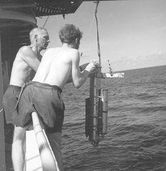 George Clarke and Roger Thomas deploy a photometer off R/V Atlantis II.