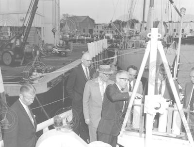 Paul M. Fye [holding buoy] with unidentified men
